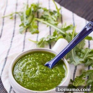 A vibrant bowl of nut-free arugula pesto, ready for use.