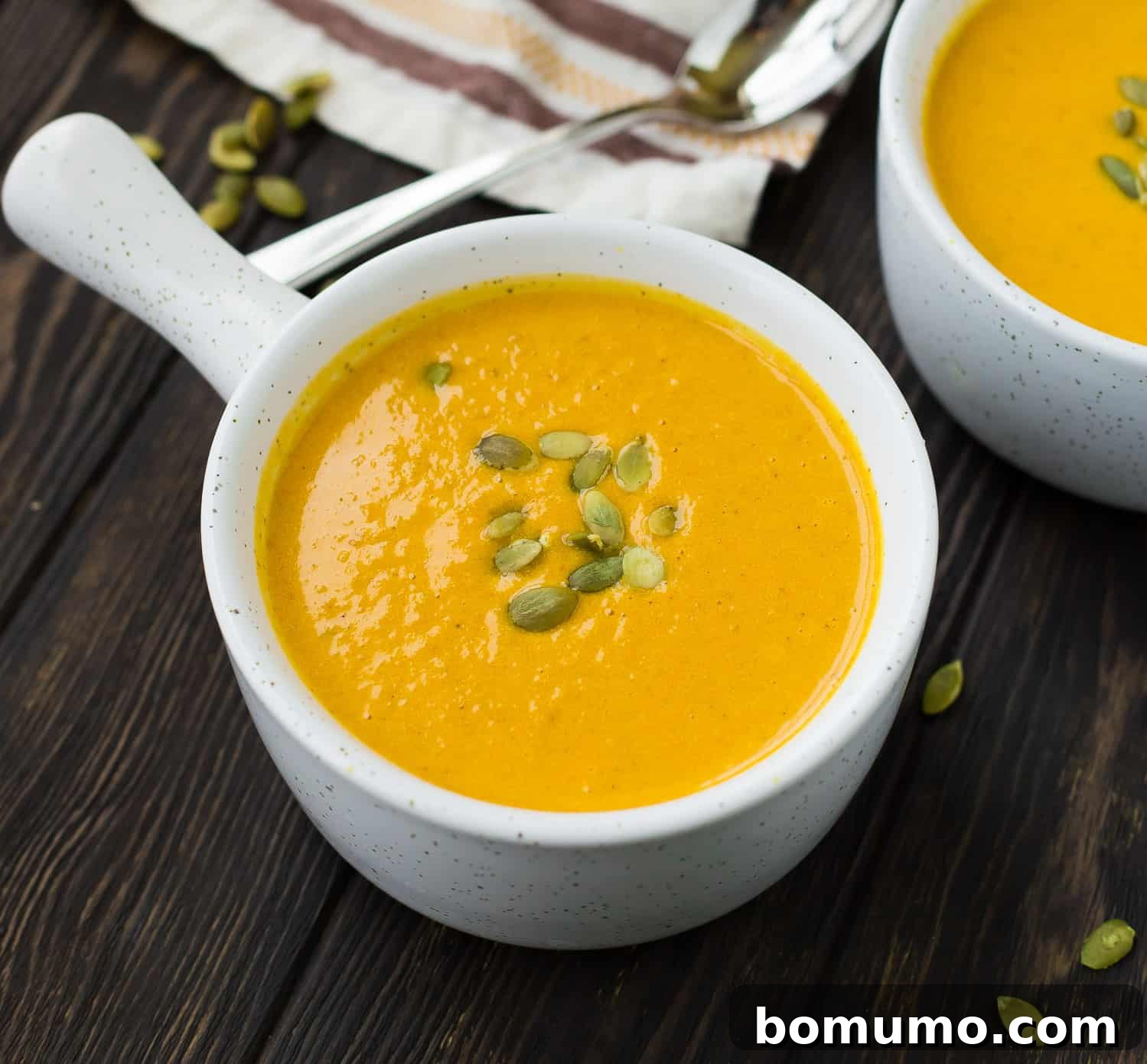 Soup in a white serving bowl with a handle.