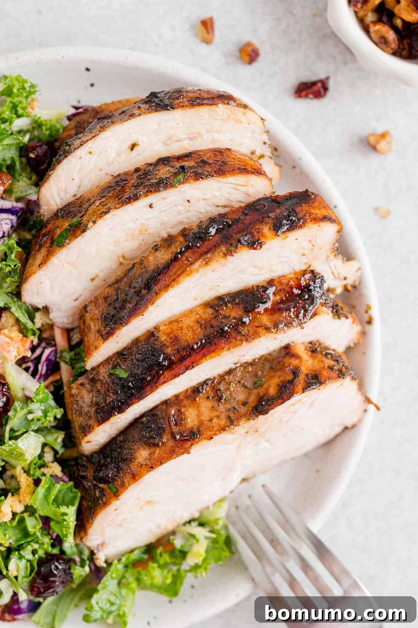 Juicy balsamic marinated chicken, perfectly cooked and served atop a vibrant salad for a light and healthy meal.