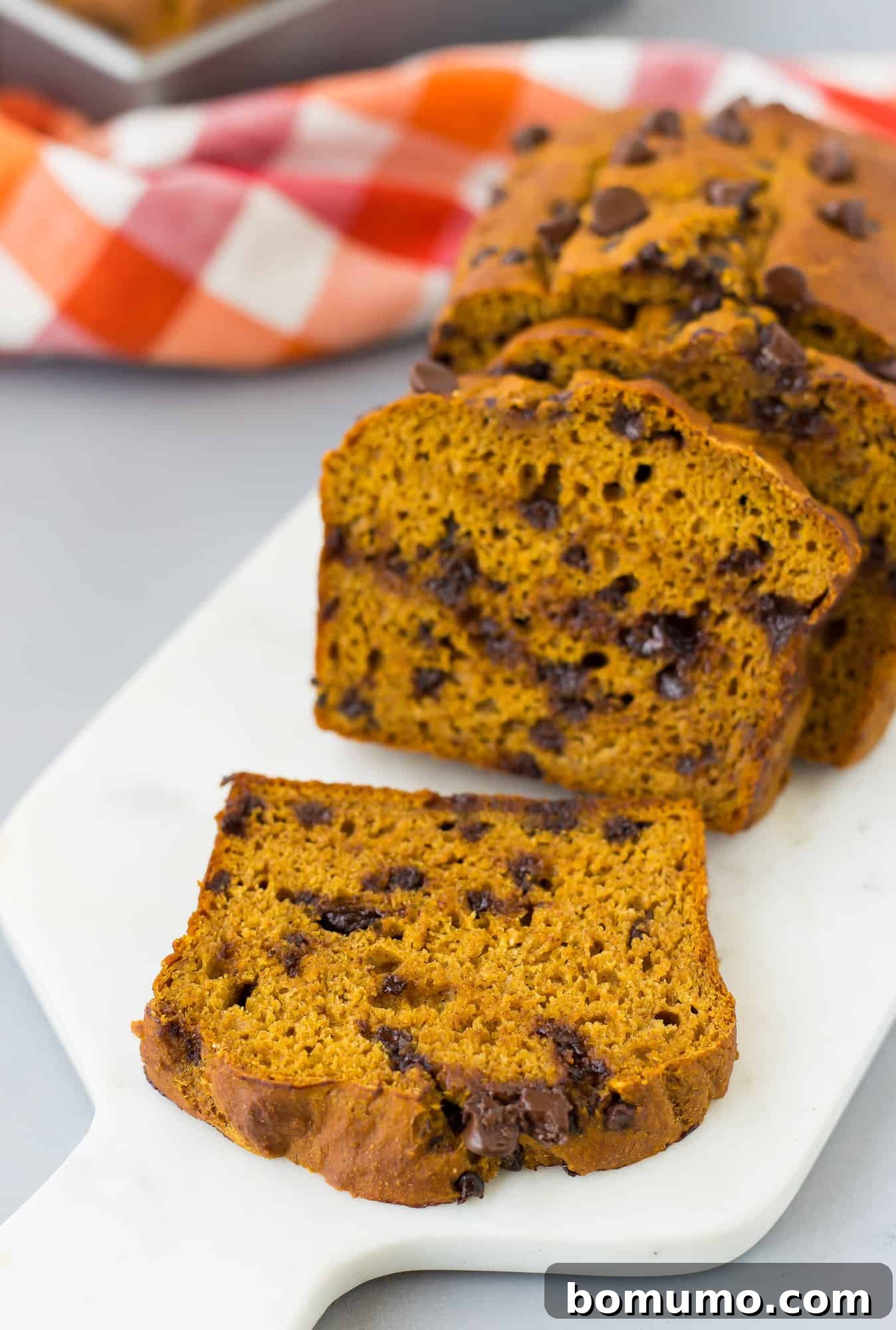Perfectly sliced pumpkin chocolate chip bread arranged on a cutting board, showcasing its moist texture and chocolate chips.