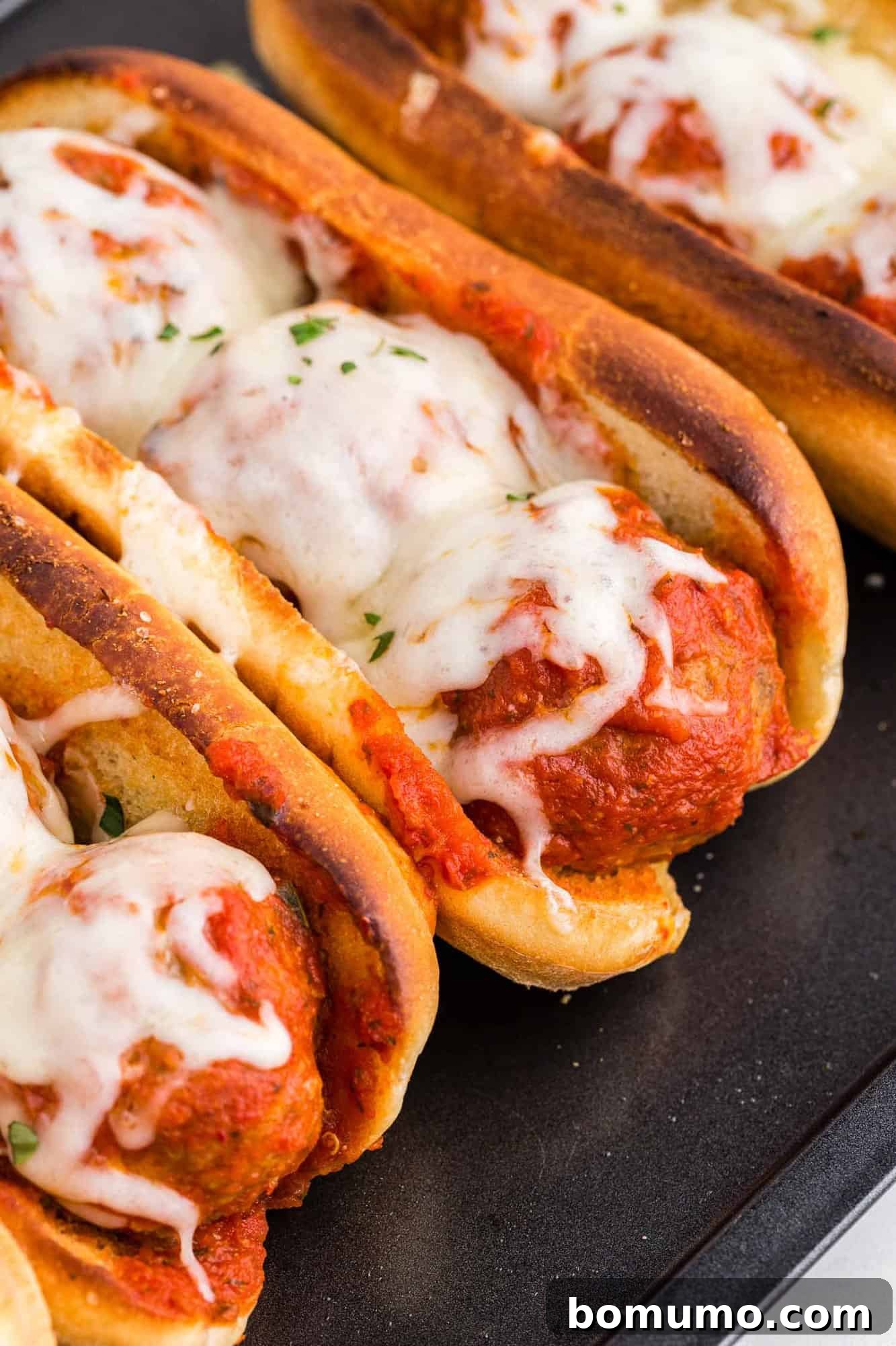 Delicious meatball subs on a platter, ready to eat.