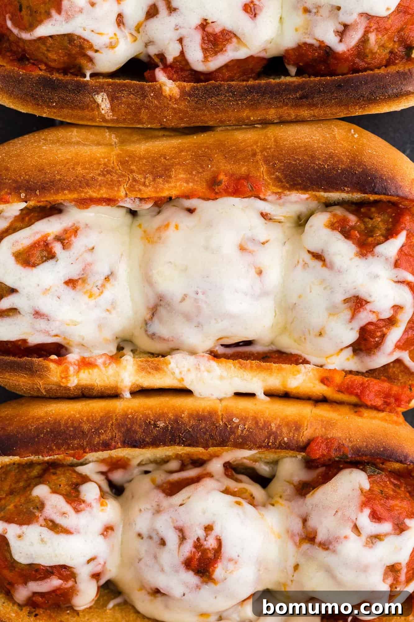 Close up of a meatball sub with perfectly melted cheese.