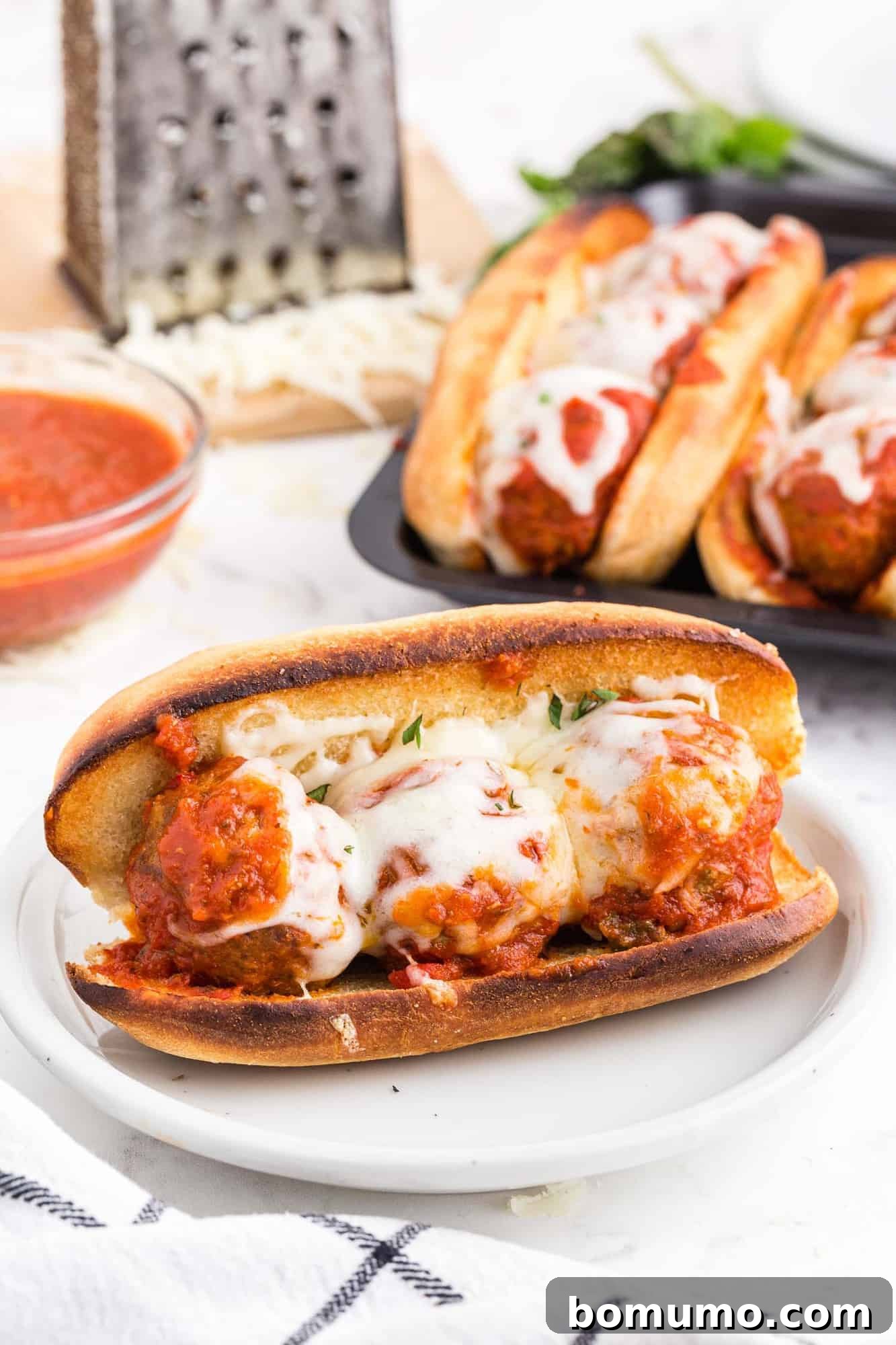 A completed meatball sub on a plate, ready to eat.