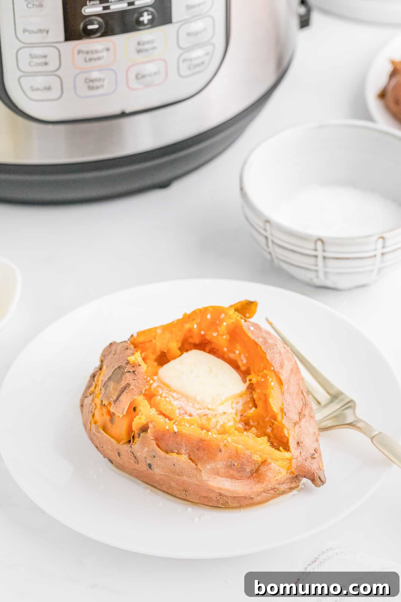 Foolproof Instant Pot Sweet Potatoes 3 Cooked sweet potato with Instant Pot pressure cooker in background.