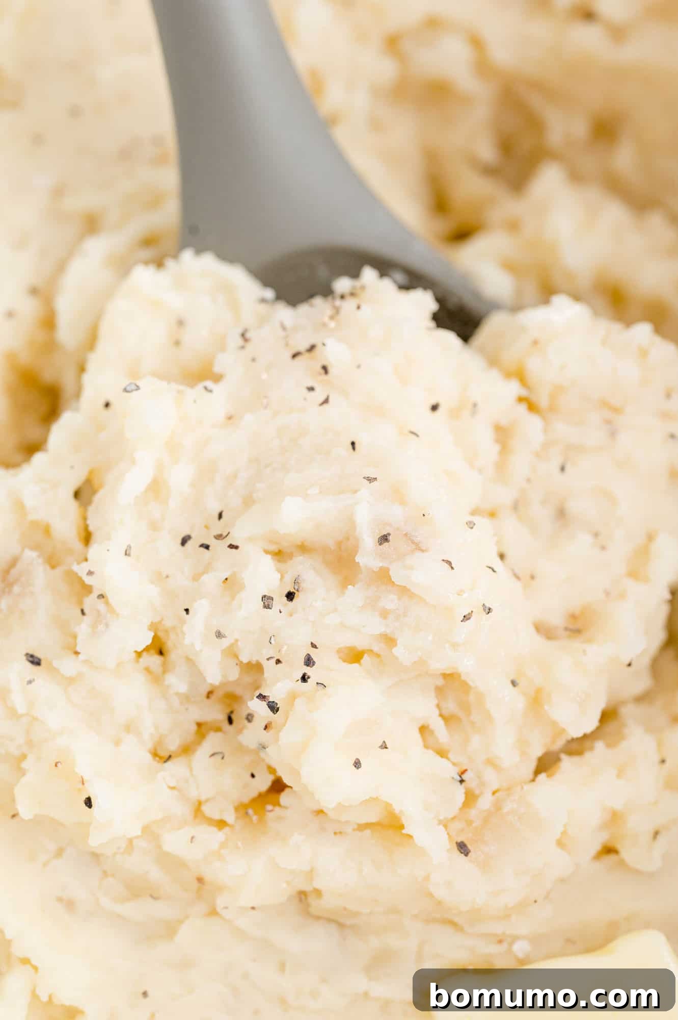 Set-It-and-Forget-It Mashed Potatoes 11 A close-up view of creamy mashed potatoes in a slow cooker, garnished and ready to be served.