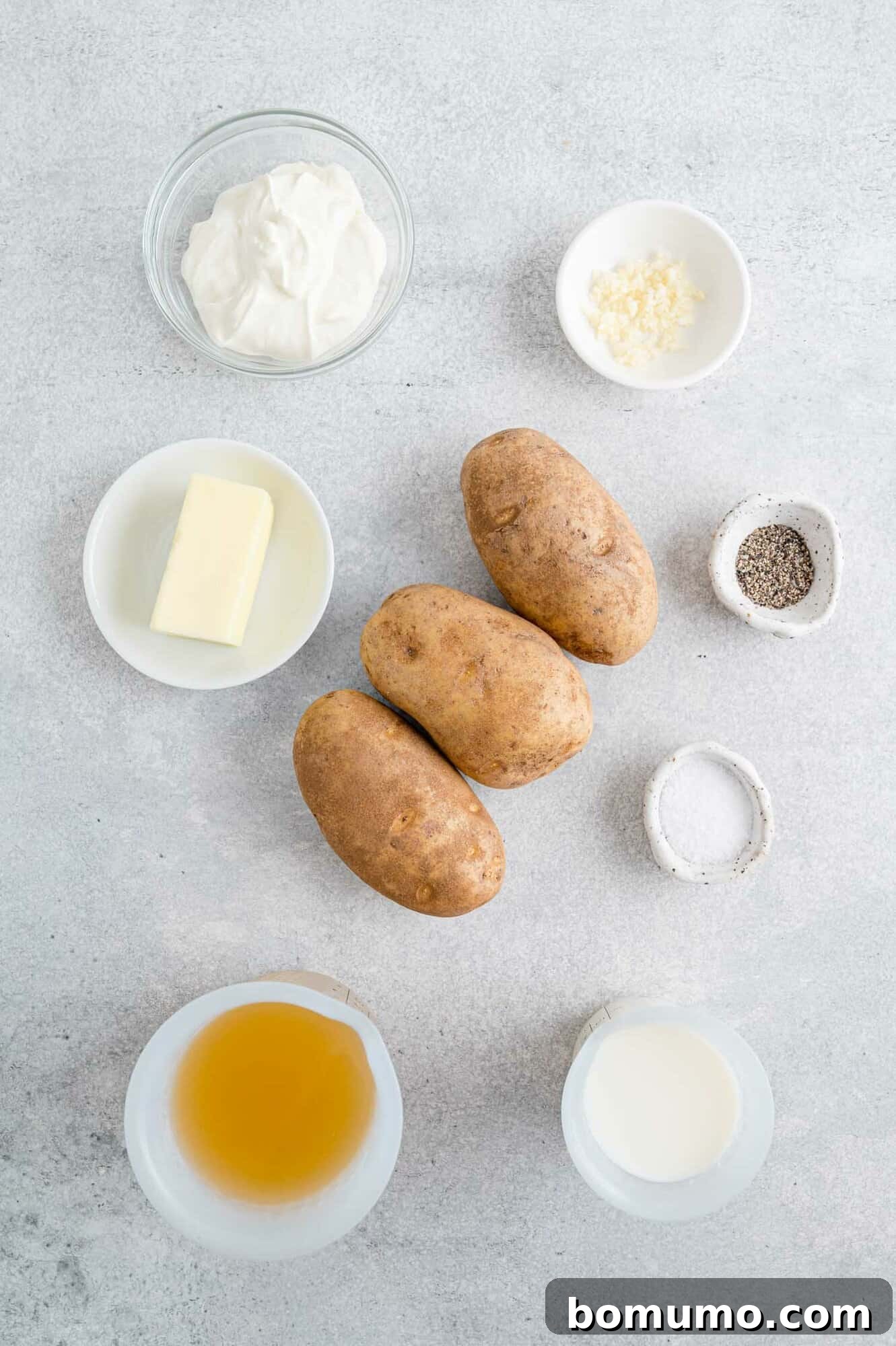 Set-It-and-Forget-It Mashed Potatoes 4 A selection of ingredients including a large bag of potatoes, broth, garlic, and butter, ready for making crockpot mashed potatoes.