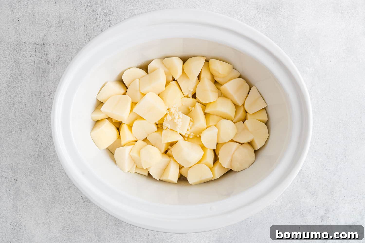 Set-It-and-Forget-It Mashed Potatoes 7 Uncooked, peeled, and cubed potatoes in a slow cooker, with broth added.