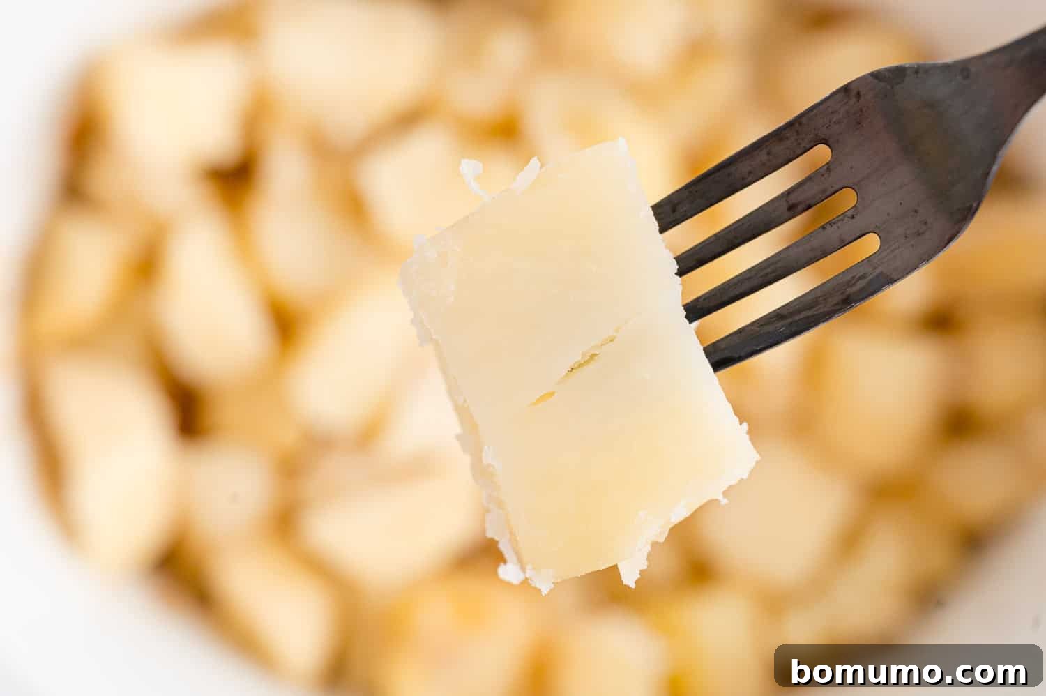 Set-It-and-Forget-It Mashed Potatoes 8 A fork easily piercing a cooked potato chunk in the slow cooker, demonstrating tenderness.