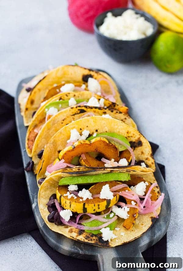 Tacos lined up on decorative black marble.