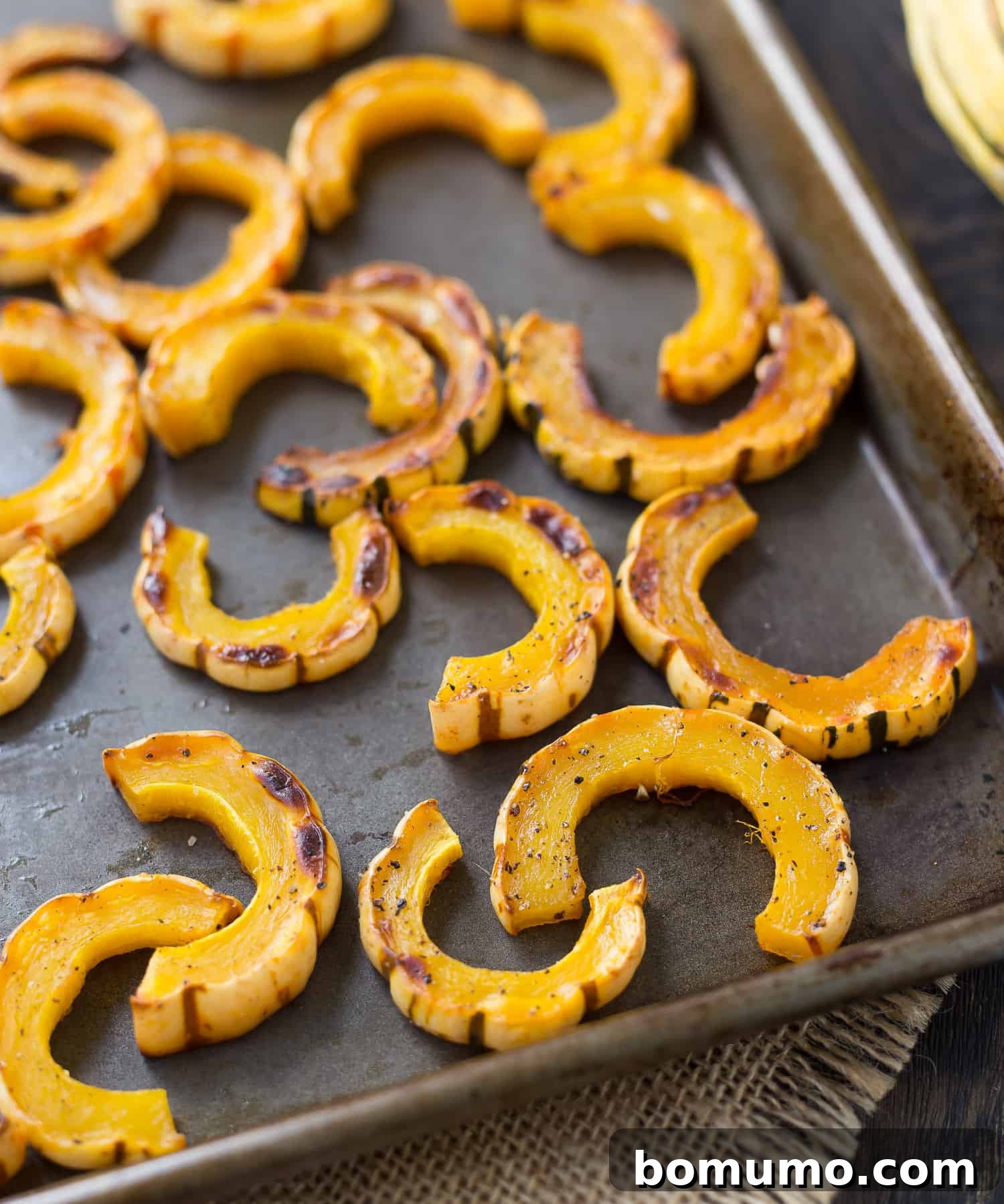 Simple Roasted Delicata Perfection 4 Crispy, golden-brown roasted delicata squash served on a parchment-lined baking sheet, glistening and ready to be enjoyed.