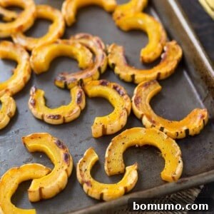 Simple Roasted Delicata Perfection 5 Roasted delicata squash on a sheet pan, ready to be served as a delicious side dish.