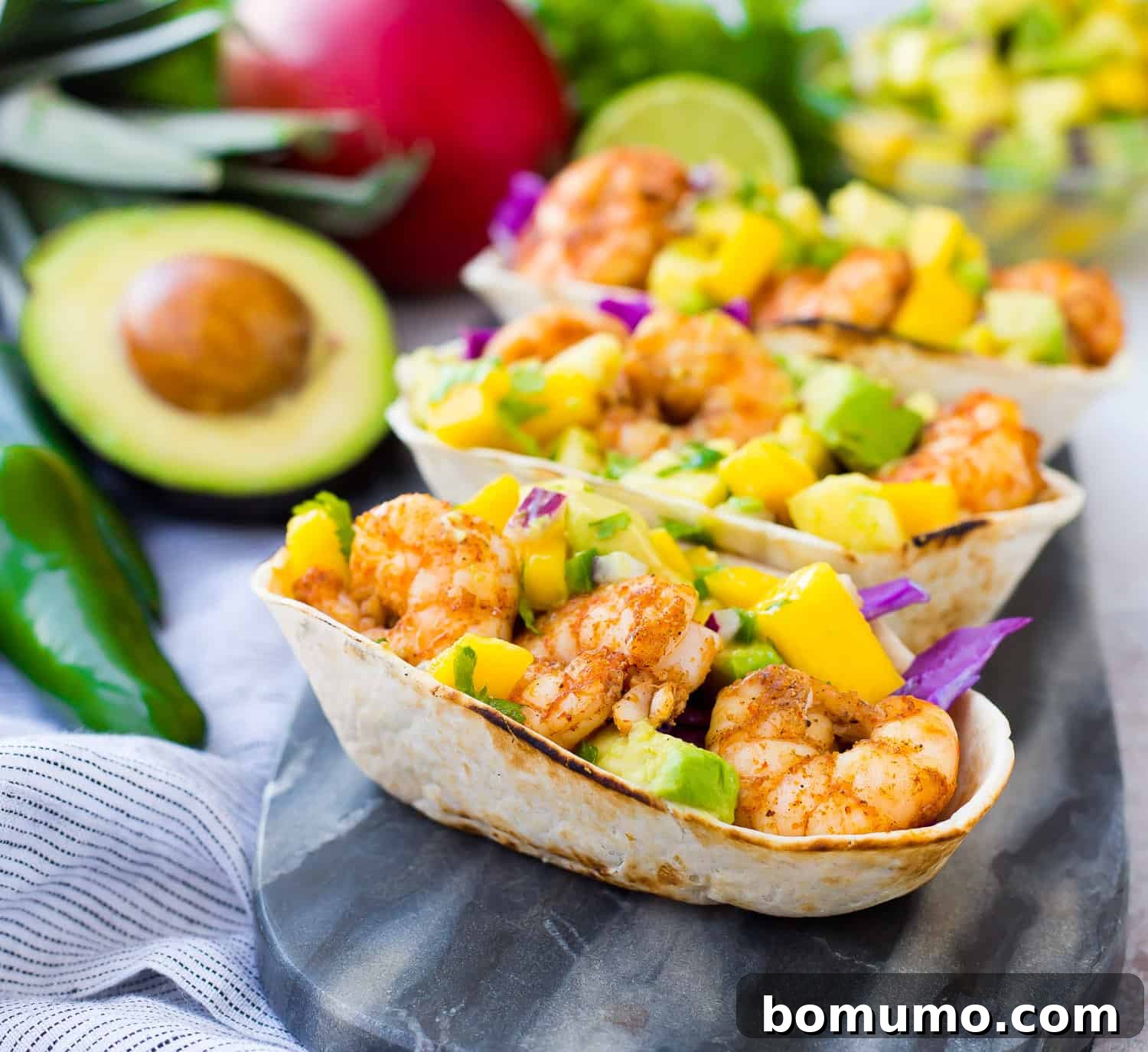 Shrimp tacos topped generously with mango avocado salsa in convenient tortilla boats.