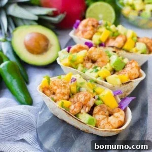 These Shrimp Tacos are a refreshing taste of the tropics thanks the zesty avocado, mango and pineapple salsa. They're easy to make and are a hit for any party or taco night.