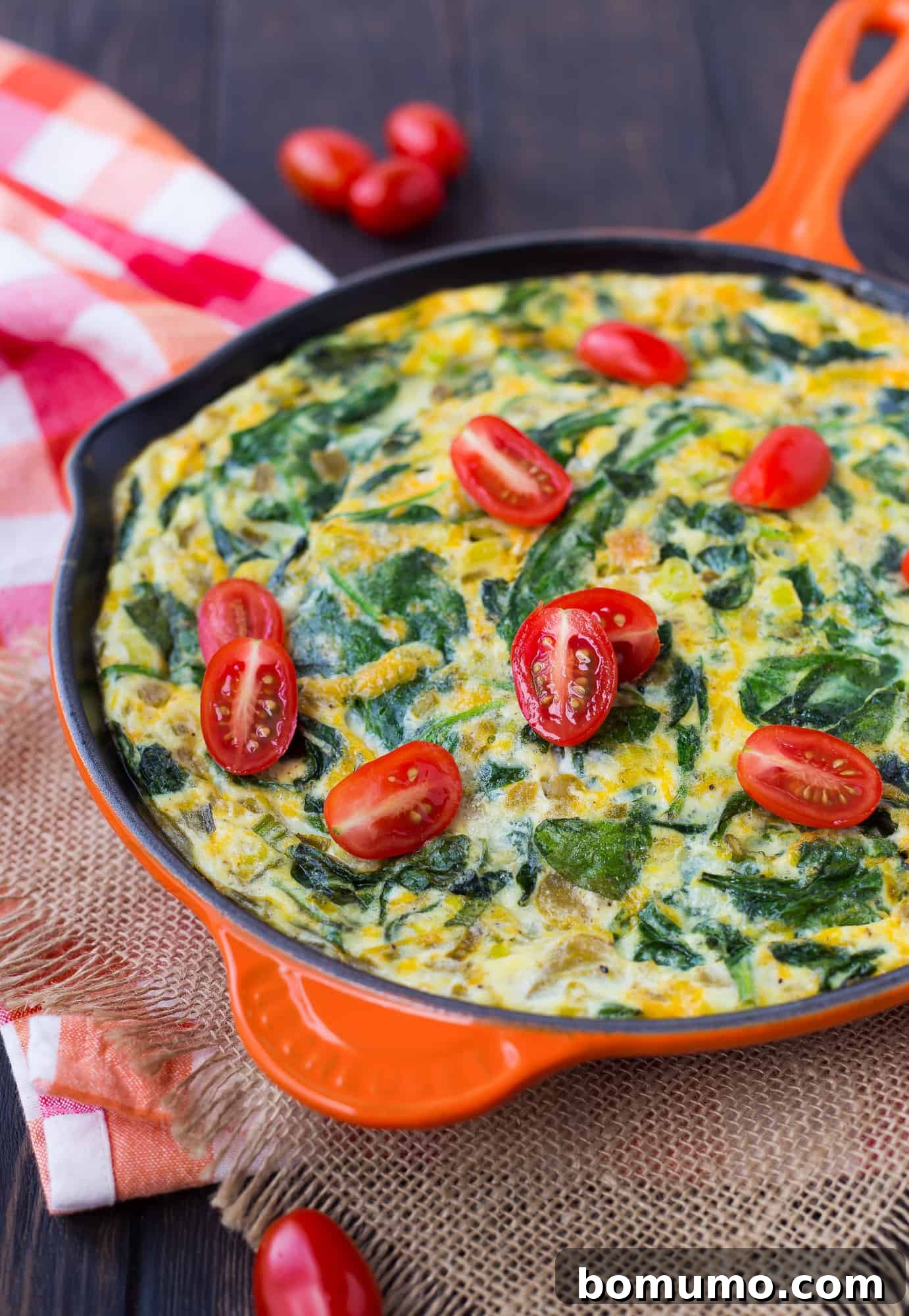 Egg White Chile Frittata 3 Vibrant green chile and spinach frittata sizzling in an orange oven-safe pan, showcasing its delicious texture.