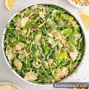 Spring orzo salad in a large white bowl.