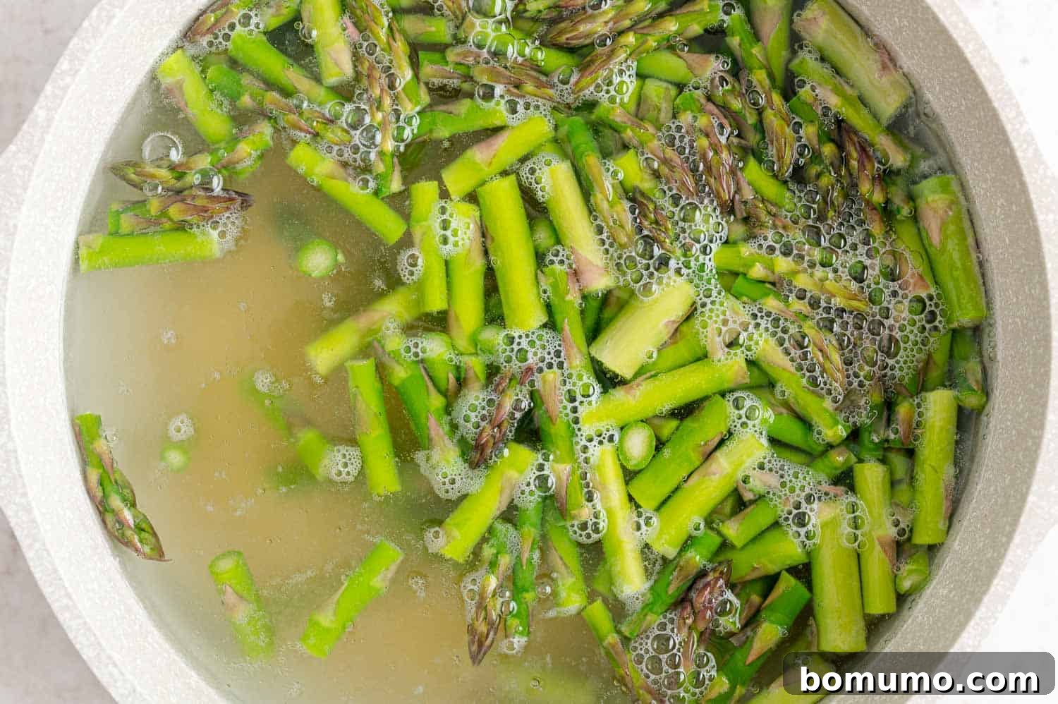 Orzo and asparagus in boiling water.