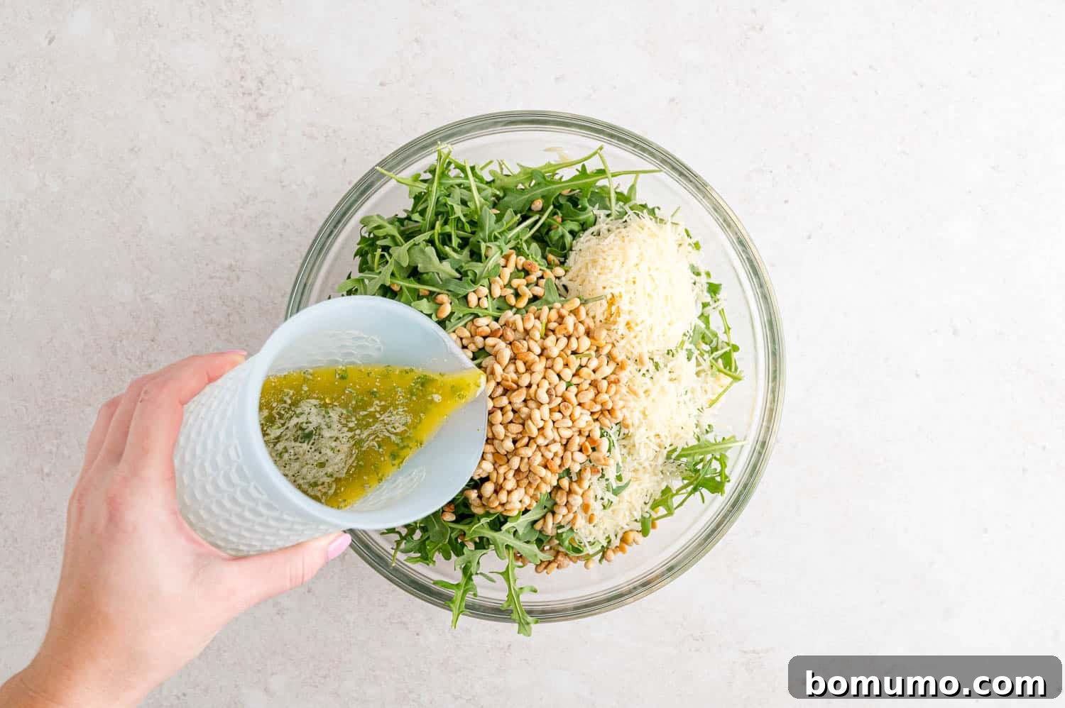 Dressing being added to salad.