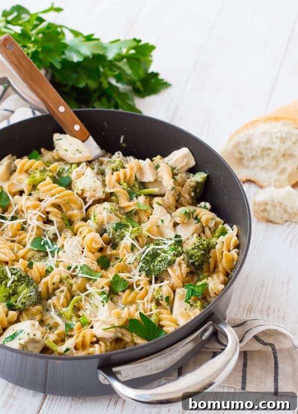 Close-up of creamy chicken Alfredo with broccoli in a large skillet