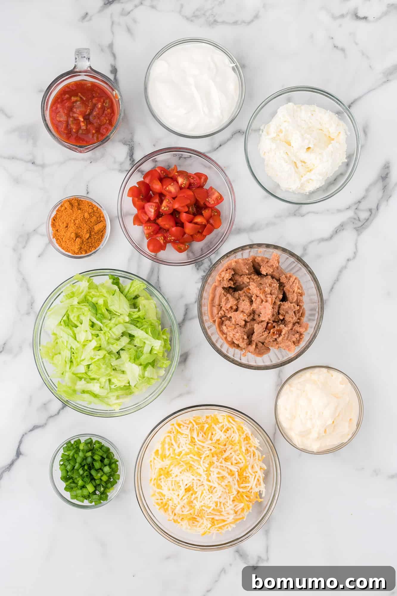 Seven-Layer Fiesta Dip 4 A collection of fresh, colorful ingredients laid out on a countertop, ready to be assembled into the delicious 7 layer dip.