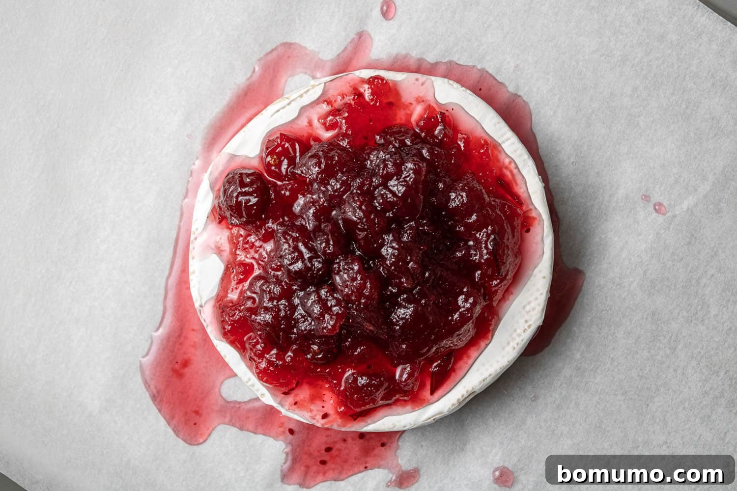 Cranberry sauce on top of a wheel of brie.