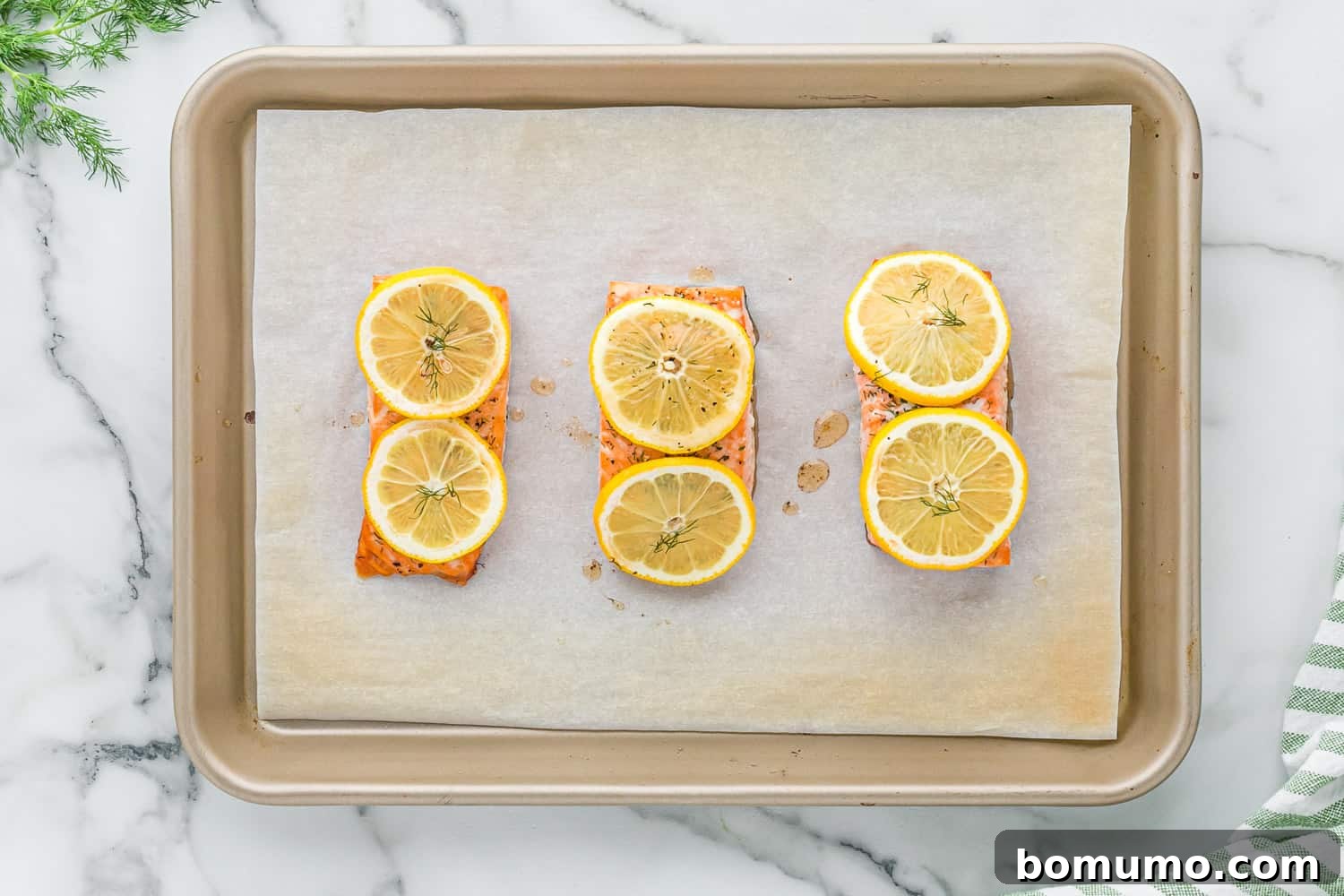 Baked salmon with lemon and dill on a sheet pan.