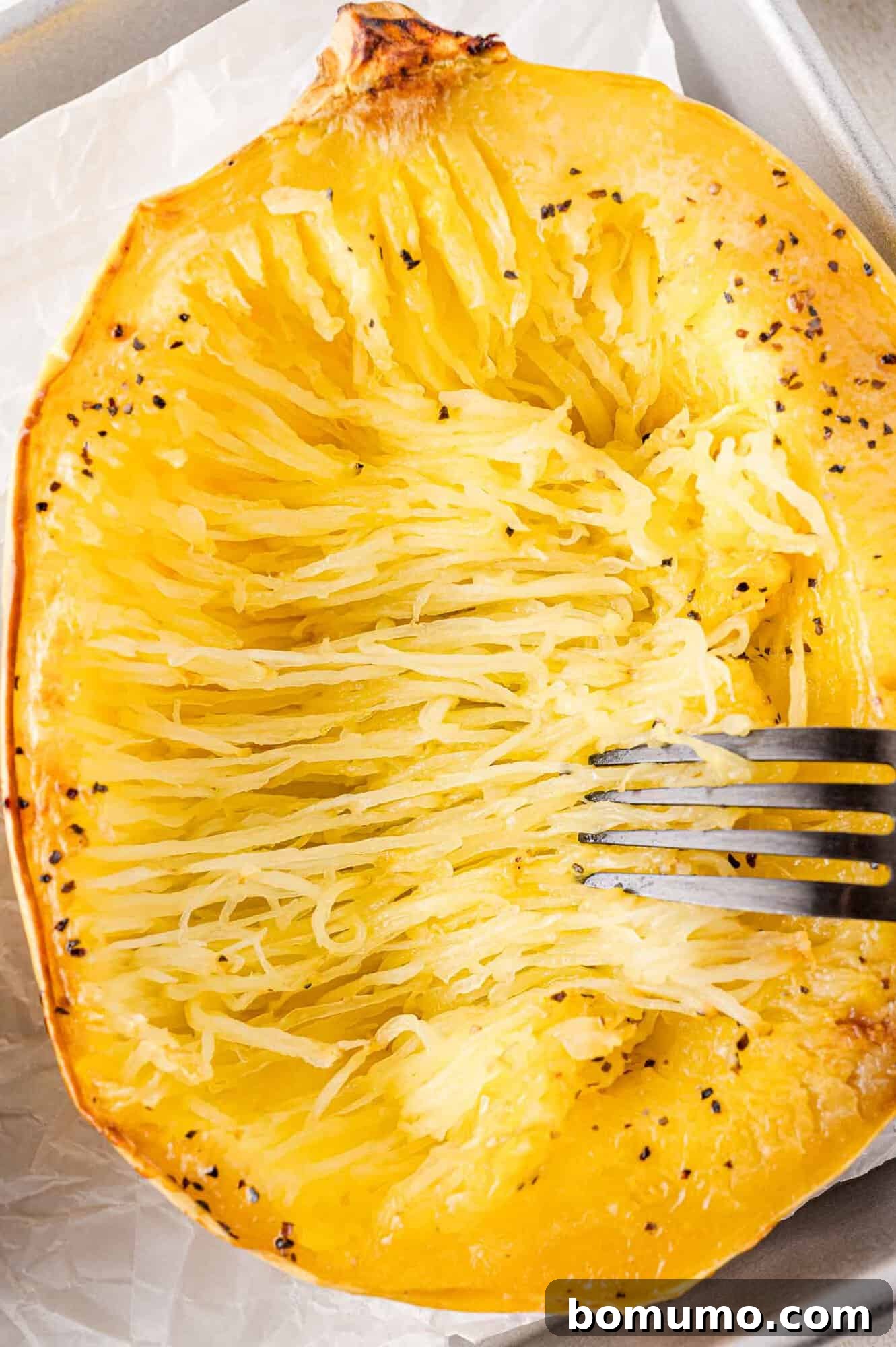 Spaghetti Squash Cooking Made Easy 13 Spaghetti squash being separated into strands using a fork.