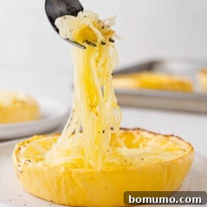 Spaghetti squash being lifted from a ring of cooked squash.