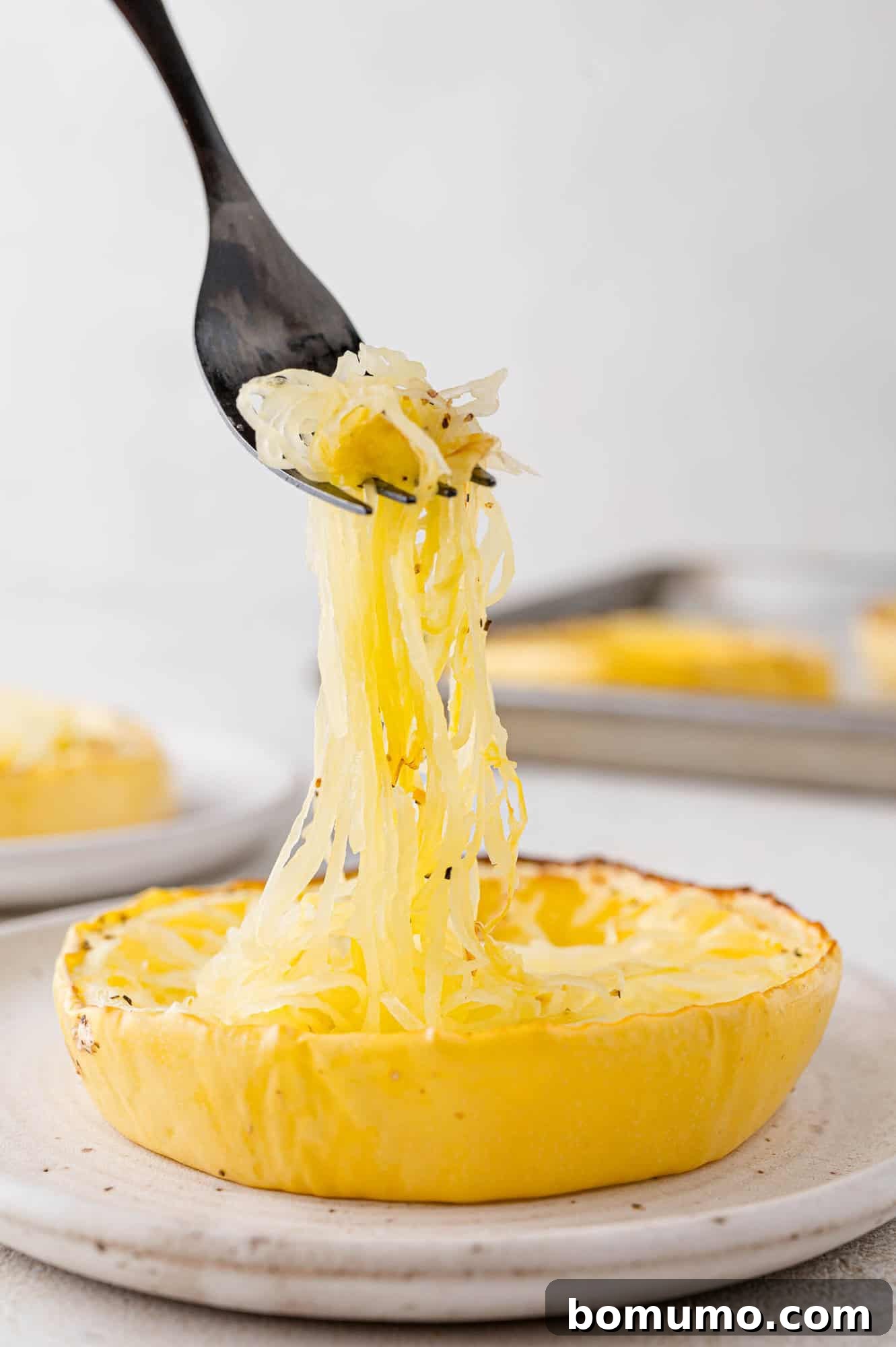 Spaghetti Squash Cooking Made Easy 6 Strands of squash being lifted from squash.