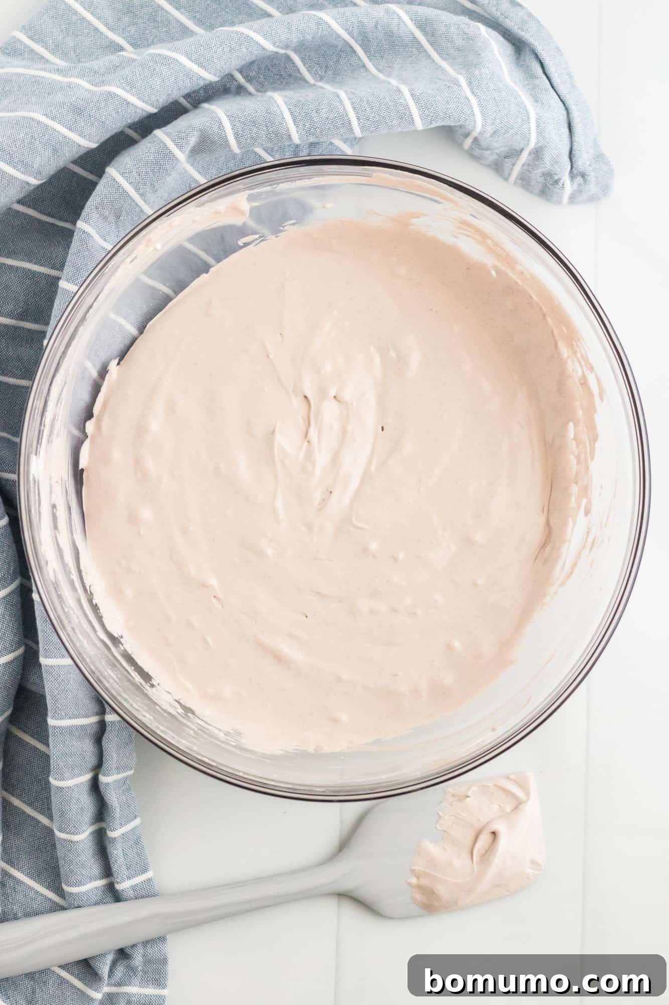 The light brown marshmallow-based dip in a clear mixing bowl, showing its smooth and airy consistency.