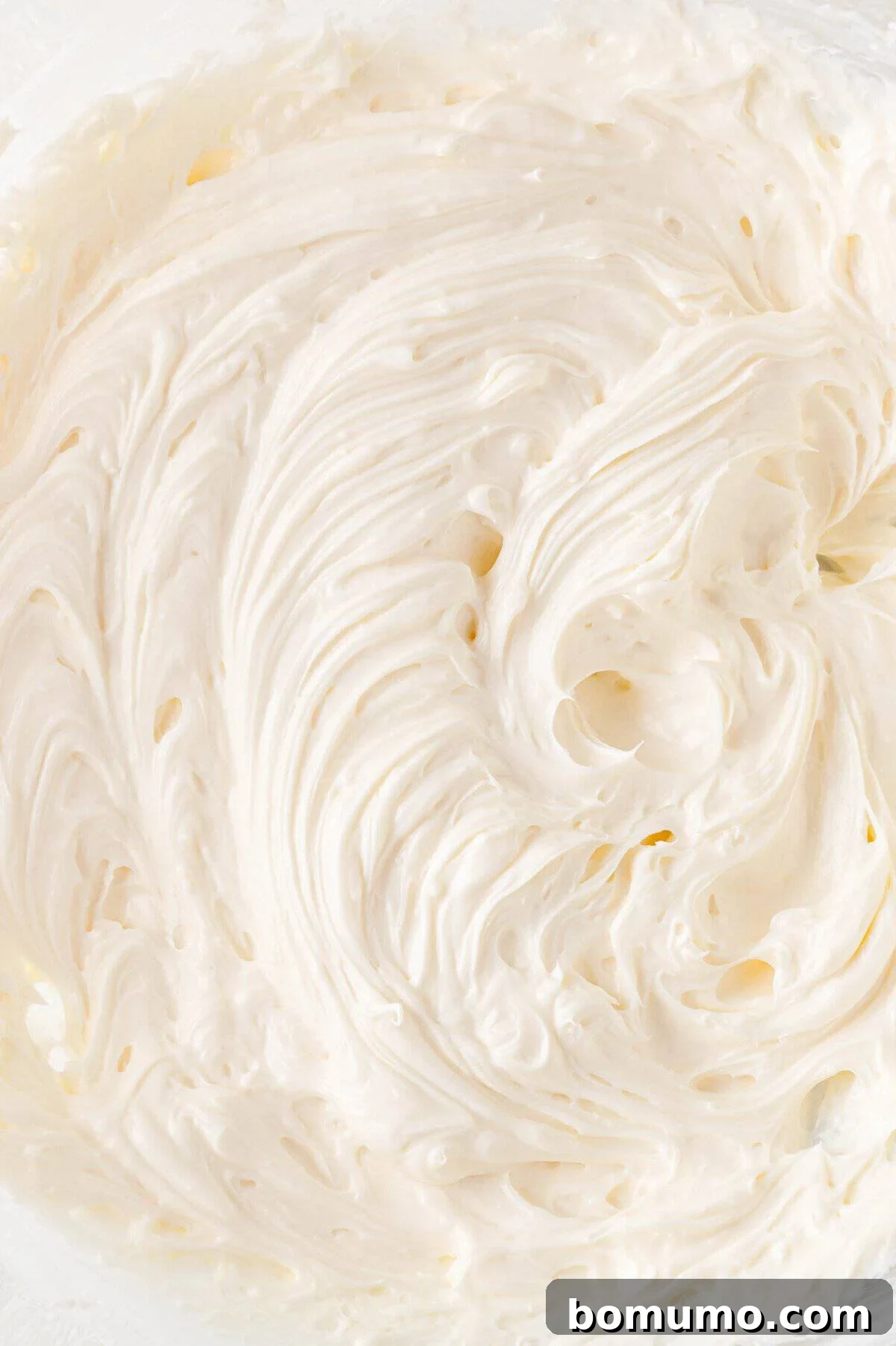Effortless Mini Cheesecake Delights 11 Close-up of smooth, creamy whipped cream cheese with a swirled texture.