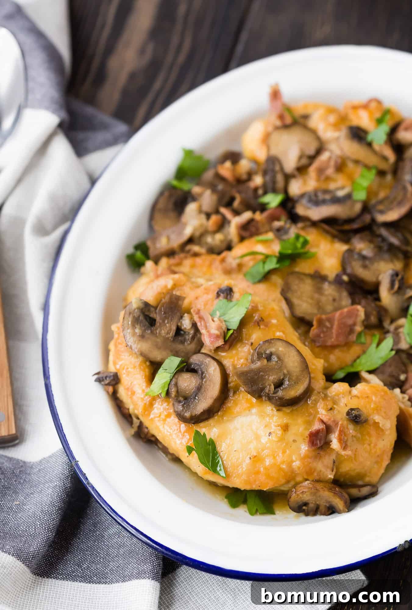 Delicious chicken cutlets with a generous helping of Marsala sauce and sliced mushrooms, garnished with fresh parsley, presented on a white serving platter.