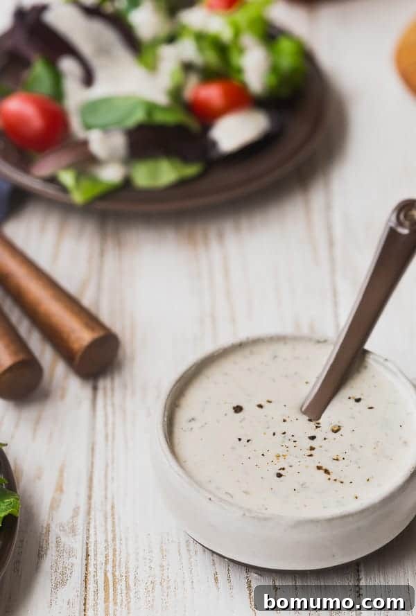 Salad dressing in a small bowl with a brown spoon. A delicious homemade dressing.