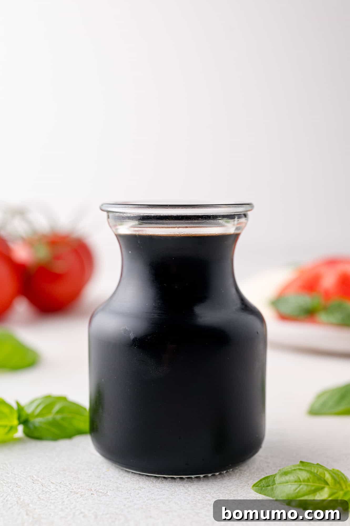 Rich balsamic reduction in a small glass carafe, ready to enhance any dish.
