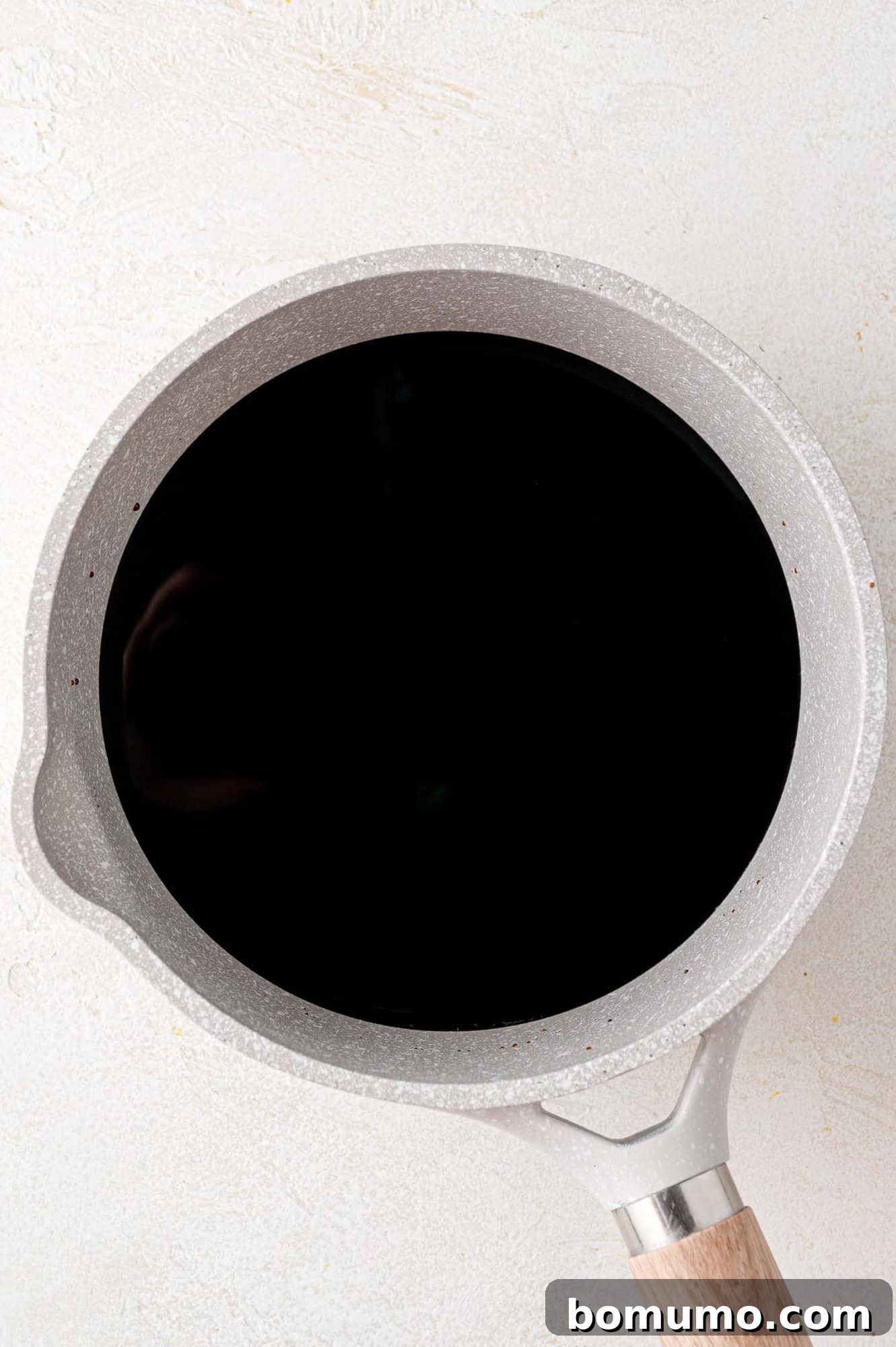 Balsamic vinegar simmering gently in a saucepan, beginning its transformation into glaze.