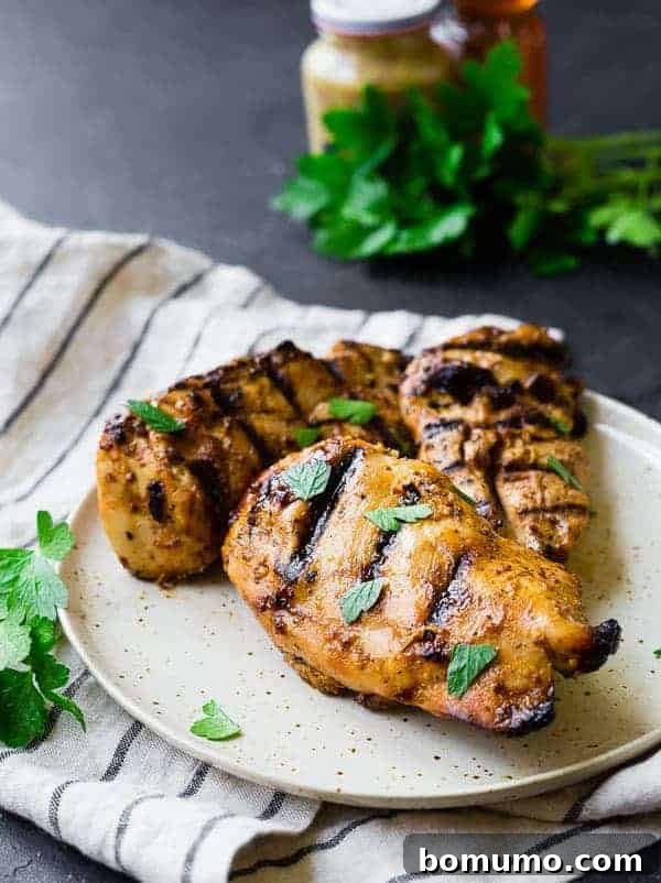 Grilled Chicken Breasts with fresh parsley garnish, showcasing a golden-brown, juicy finish from honey mustard marinade.