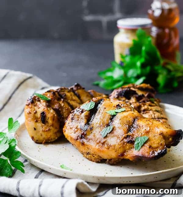 Close-up front view of a single grilled chicken breast on a small plate, seasoned and ready to eat.