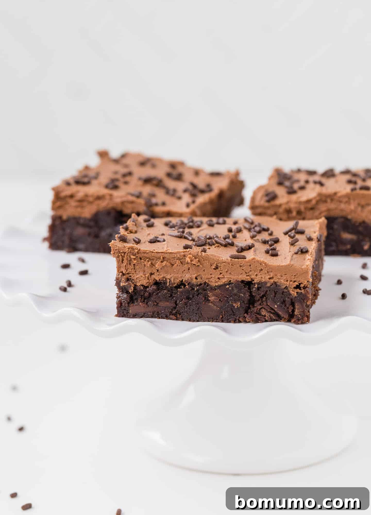 Effortless Mocha Brownies 5 White plate with frosted brownies.