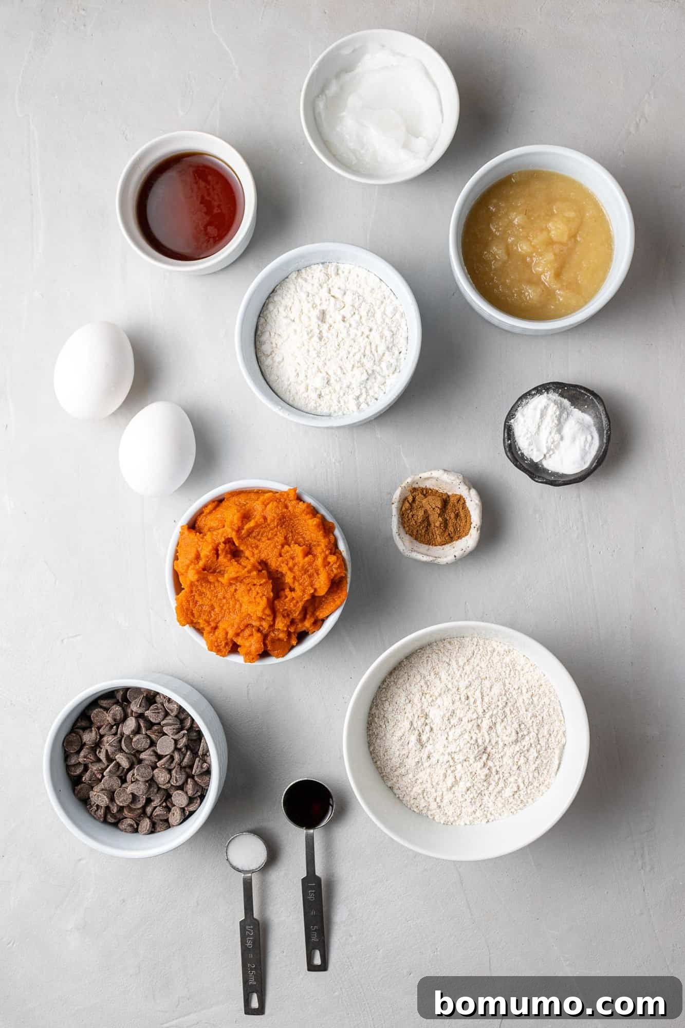 Overhead view of fresh ingredients for healthy pumpkin chocolate chip muffins laid out on a kitchen counter.