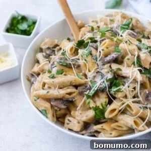 Chicken marsala pasta with a wooden spoon.