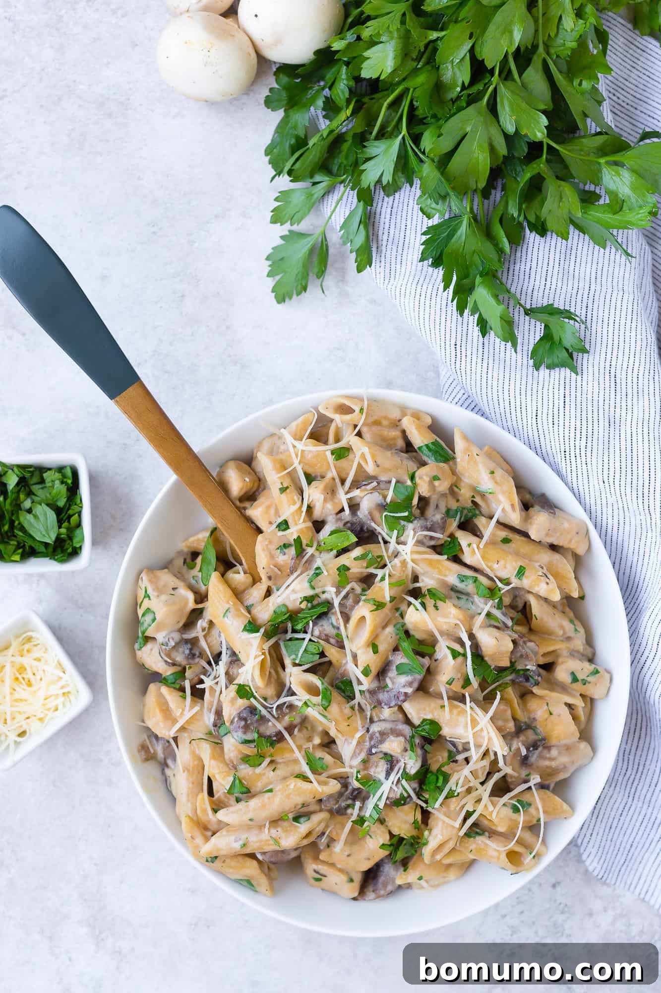 Overhead view of marsala pasta topped with cheese and parsley.