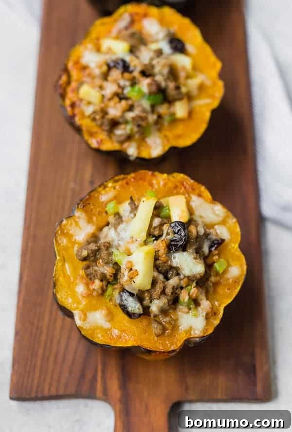Overhead view of perfectly baked and stuffed acorn squash halves arranged on a rustic wooden serving platter, ready to be enjoyed.