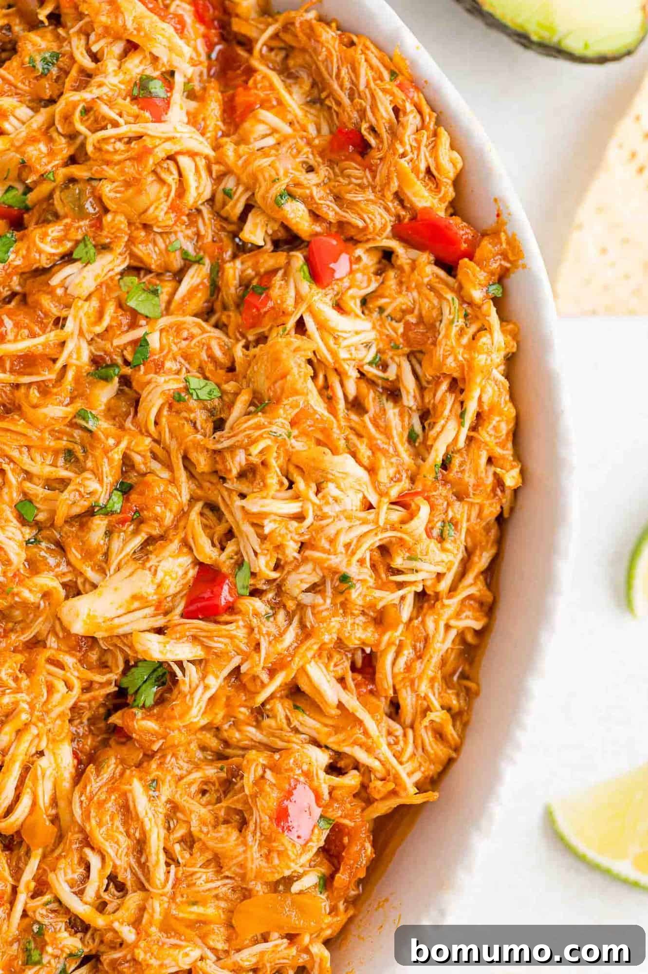 Overhead partial view of a large bowl of crockpot salsa chicken.