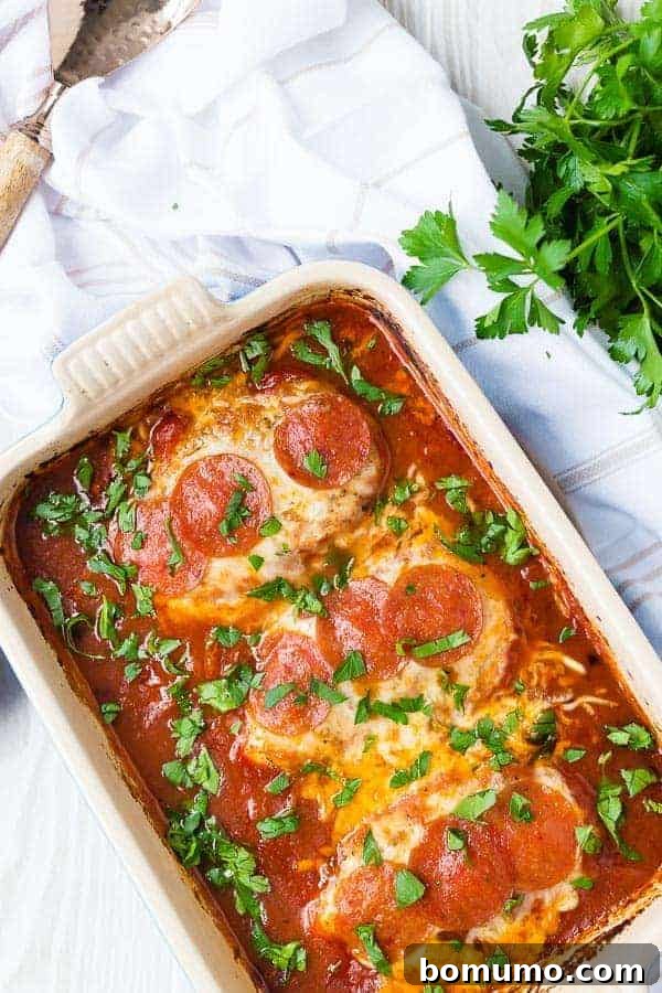 Golden-brown pizza chicken, generously topped with melted mozzarella cheese and crispy pepperoni slices, baked in a rectangular dish.