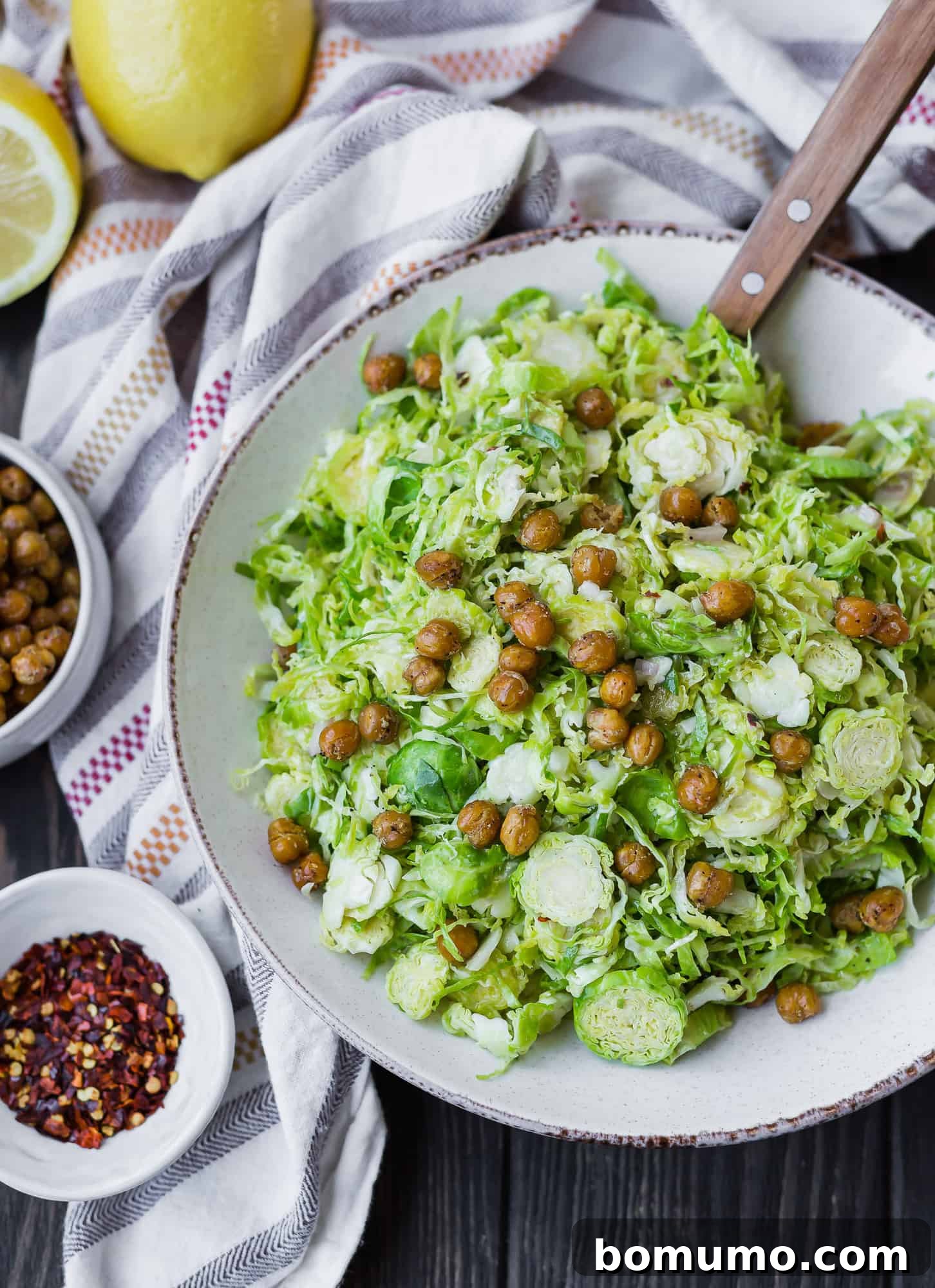 Close-up of a vibrant salad featuring shaved Brussels sprouts, interspersed with golden, crispy chickpeas.