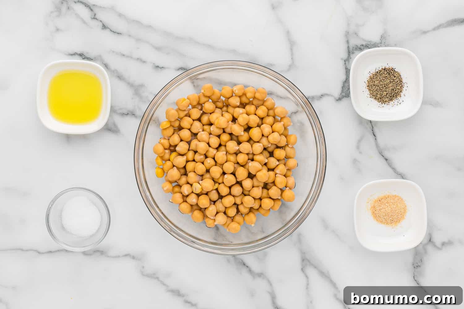 Overhead view of ingredients needed including chickpeas, olive oil, salt, and pepper for crispy chickpeas.