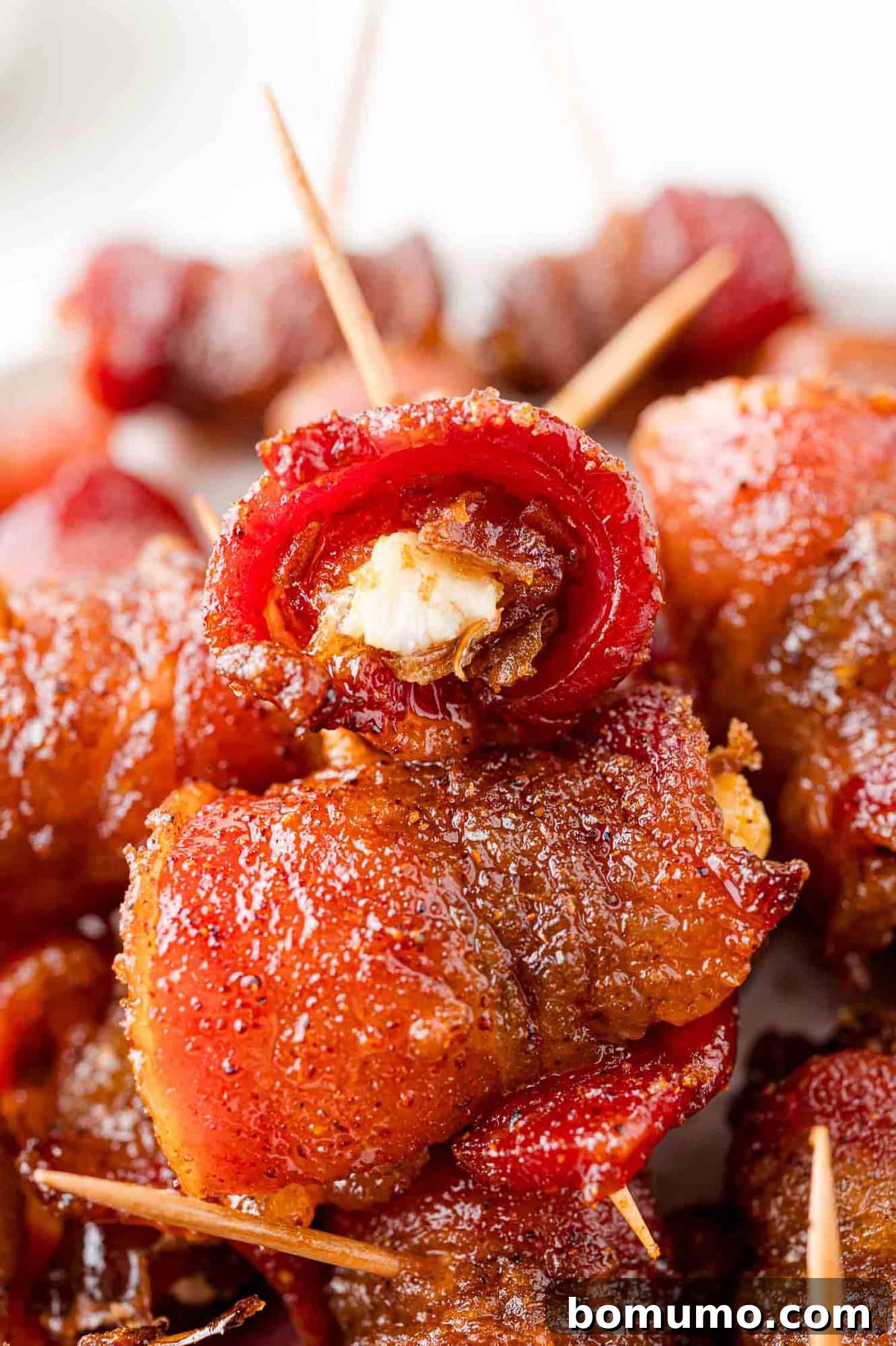Pile of bacon wrapped dates, stuffed with goat cheese and secured with a toothpick.