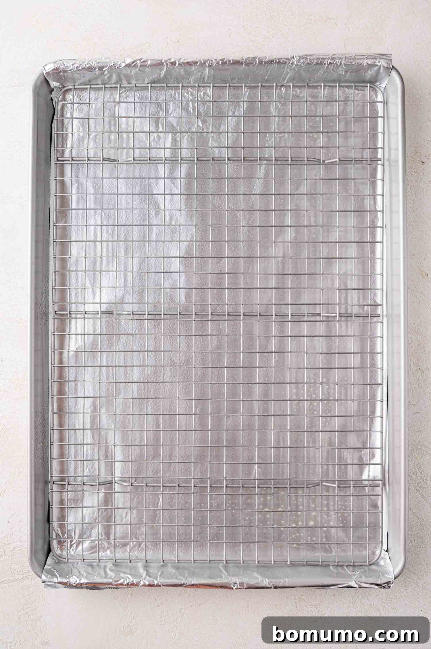 Sheet pan lined with foil, wire cooking rack placed on top.