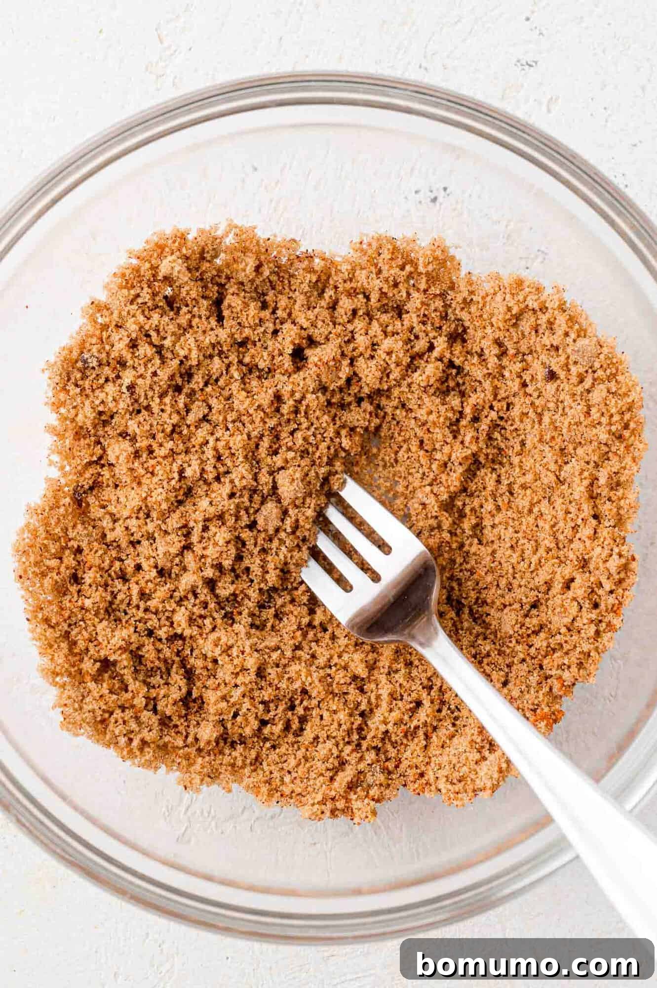Spice rub for bacon wrapped dates, being stirred with a fork.