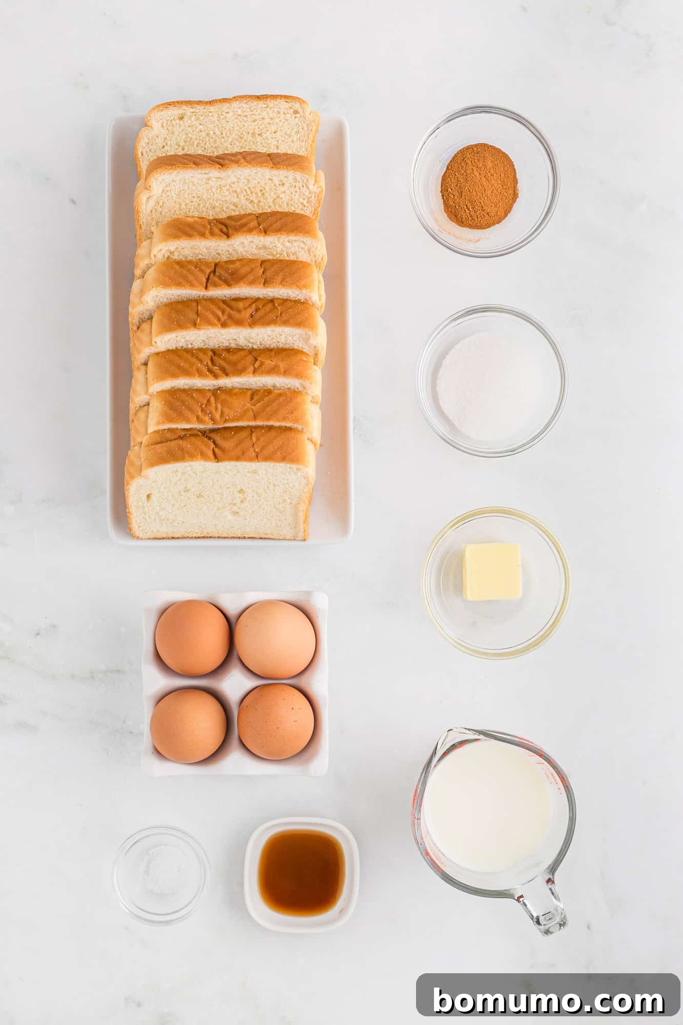Overhead view of French toast ingredients including bread and eggs.