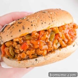 Hand holding a sloppy joe sandwich.